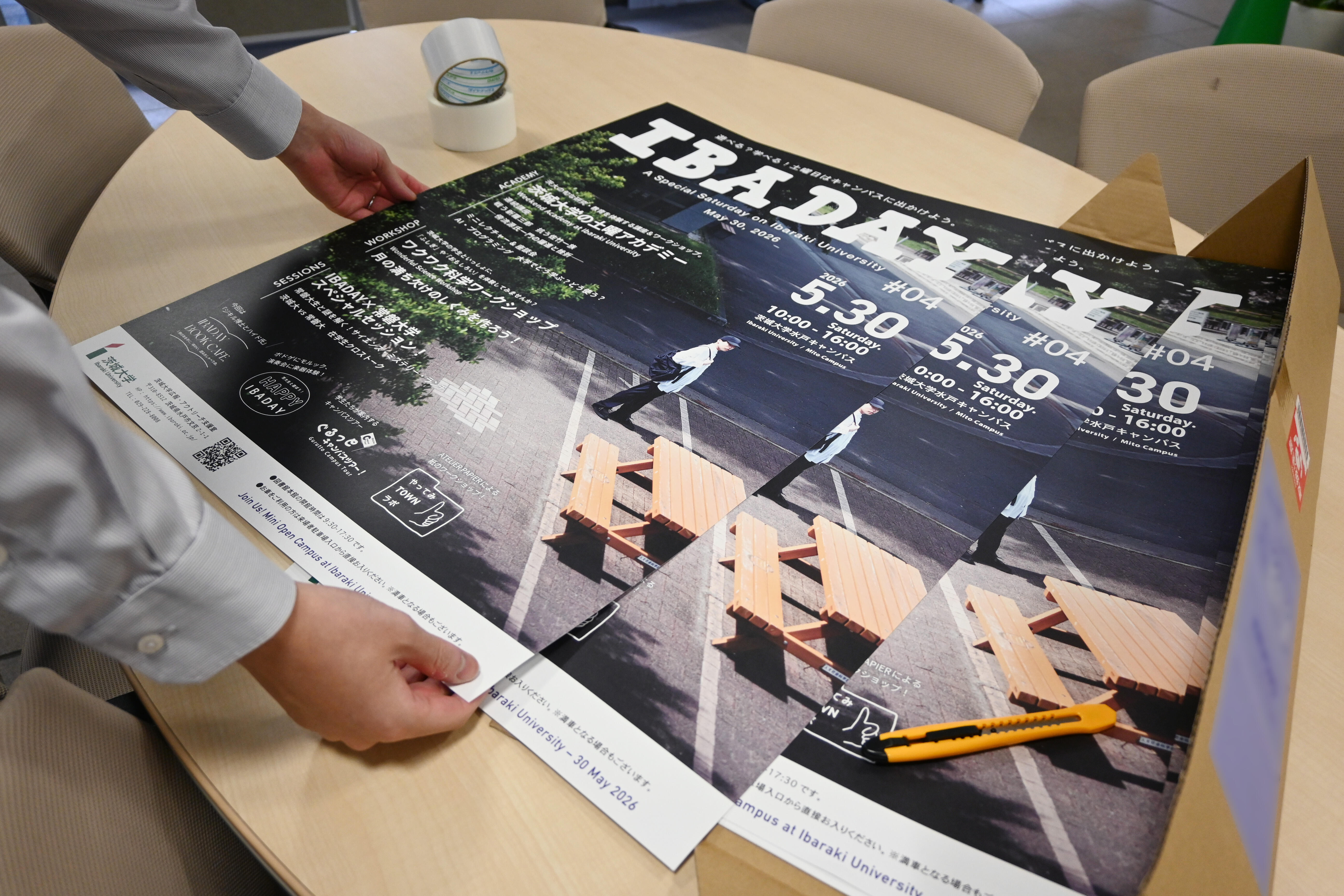 IBADAYのポスターを職員が箱から取り出している